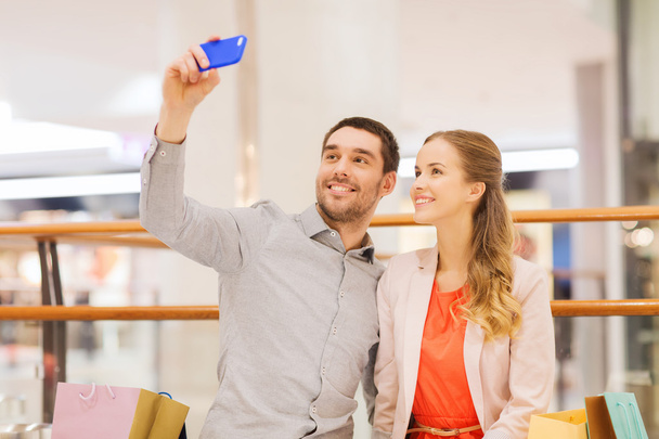 happy couple with smartphone taking selfie in mall - Φωτογραφία, εικόνα