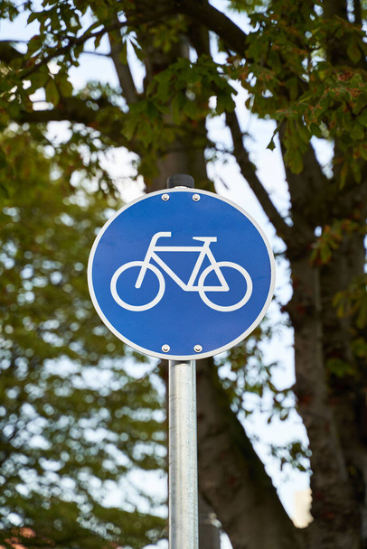 Road signs for cyclists. Bike visible on blue sign. Nature out of focus visible in the background. Environmentally conscious mobility.                                - Fotó, kép