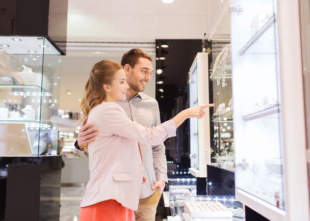 couple looking to shopping window at jewelry store - Foto, Imagen