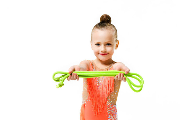 Gymnastic acrobatic athlete girl elementary school age pose with jumping rope in studio isolated background - Photo, Image