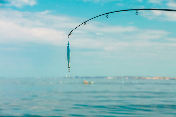 saltwater fishing - rod with wobbler and blue sea water - Fotoğraf, Görsel