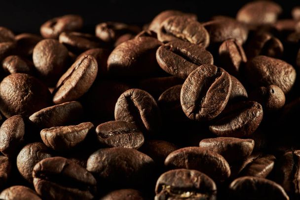 Roasted coffee beans isolated close up on black background, clipping path - Fotoğraf, Görsel