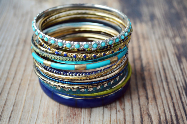 Hermosas pulseras de oro caros sobre fondo de madera
 - Foto, Imagen