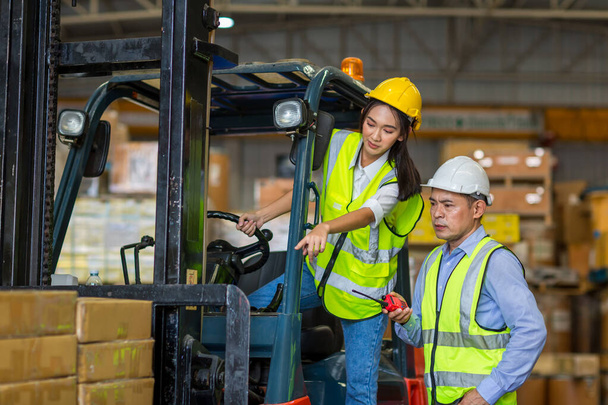 Worker at forklift driver working in industry factory logistic ship. Woman forklift driver in warehouse area. - Foto, afbeelding