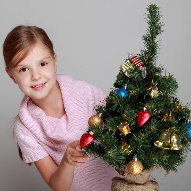 Smiling girl near a Christmas tree - Foto, Imagen