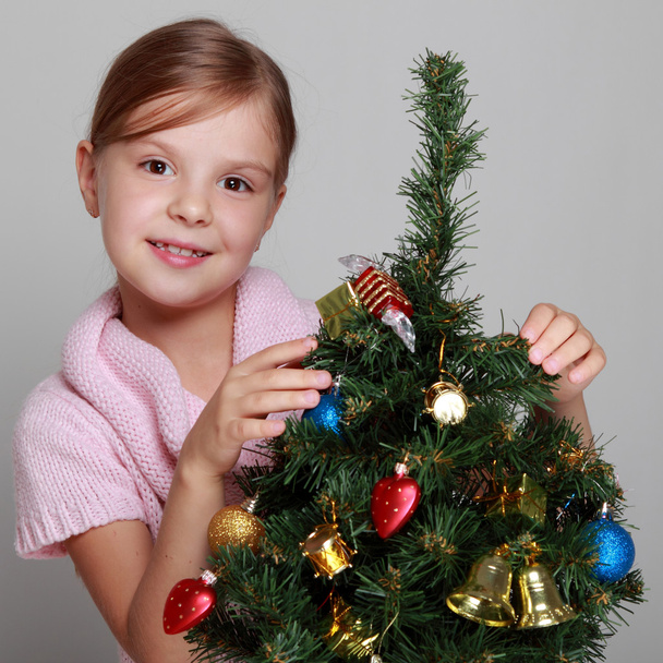 Child near a decorated Christmas tree - Foto, Imagen