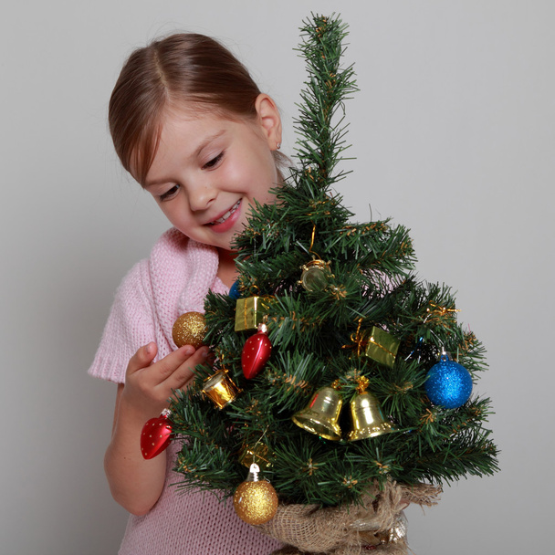 Smiling girl near a Christmas tree - Fotó, kép