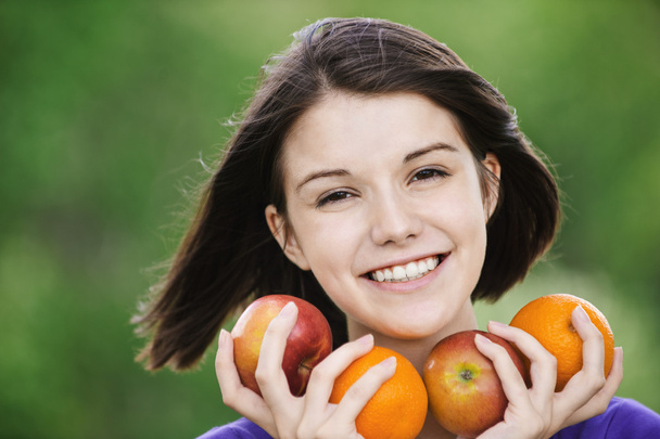若い陽気な女性保持果物 - 写真・画像