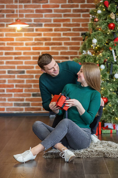 Man giving Christmas present to girlfriend. Cozy house. Merry christmas celebration concept - Фото, зображення