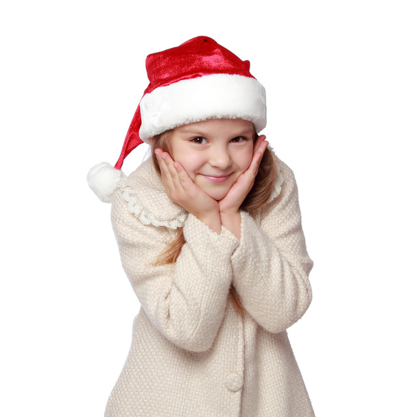 Lovely child in a Santa hat is happy and laughs - Fotó, kép