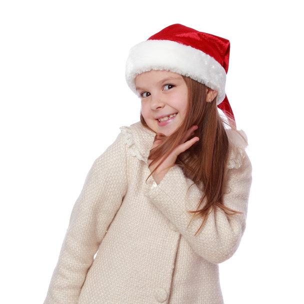 Lovely child in a Santa hat is happy and laughs - Foto, Imagen