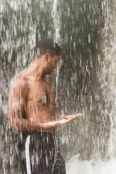 Człowiek stojący pod wodospadem w Maroku - Zdjęcie, obraz