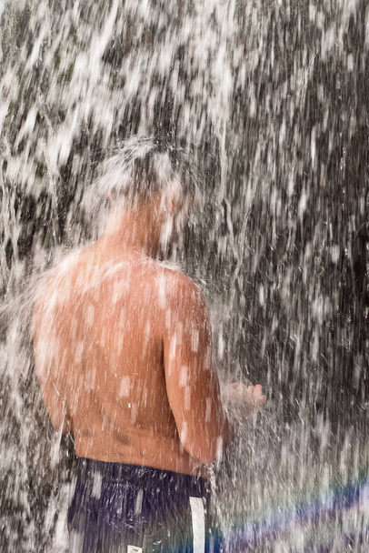 Un hombre parado bajo una cascada en Marruecos - Foto, imagen