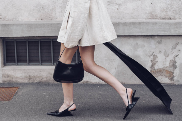 Milan, Italy - February, 24: Street style, woman wearing cream leather jacket, mini skirt with long train, black Prada bag and Prada heels. - 写真・画像