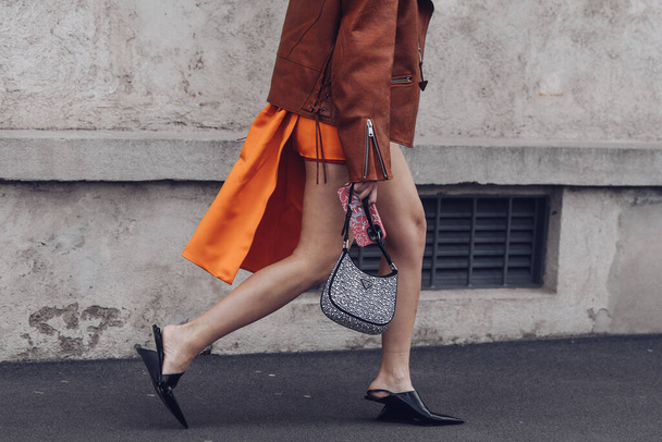 Milan, Italy - February, 24: Street style, woman wearing a black turtleneck top, orange mini skirt with train, black heels and Prada bag. - Photo, image