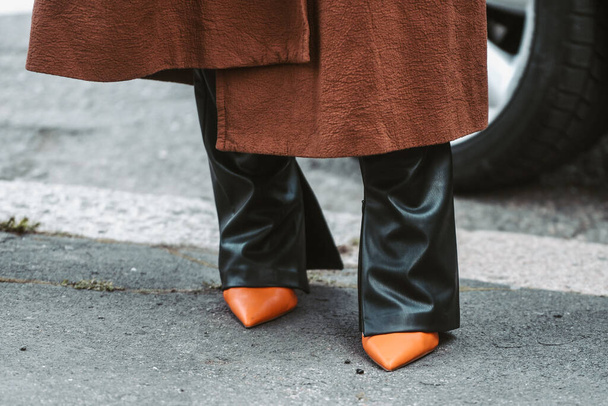 Milan, Italy - February, 24: Street style, woman wearing a brown oversized coat, black leather pants and neon orange shoes. - Foto, Imagem