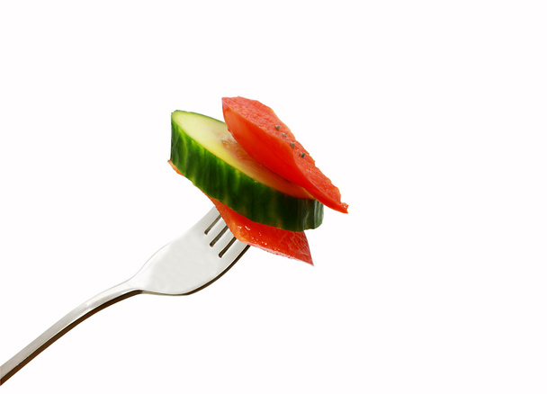 Tranche de poivron rouge et concombre sur la fourchette
 - Photo, image