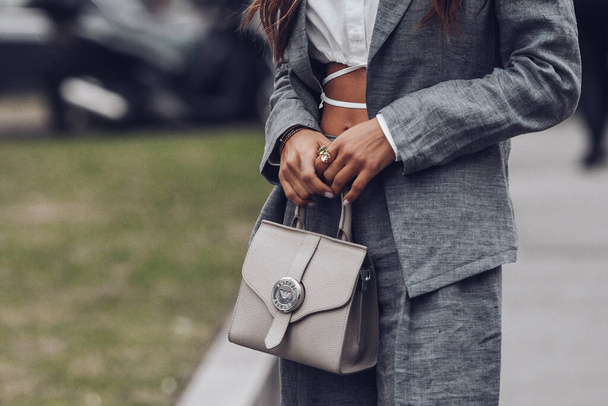 Milan, Italy - February, 24: Street style, woman wearing white cropped shirt, a gray blazer jacket, gray matching suit pants, a beige leather handbag and yellow green open toe-cap pumps sandals. - Fotoğraf, Görsel