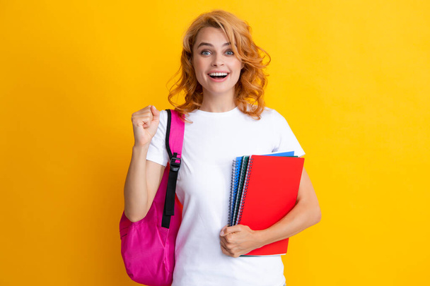 Portrait of smiling female student with books. Happy girl with a backpack. Beautiful woman hold study applies back bag - Foto, Imagem