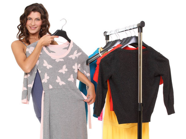 вешалки с одеждой, женщина выбирает одежду - Фото, изображение