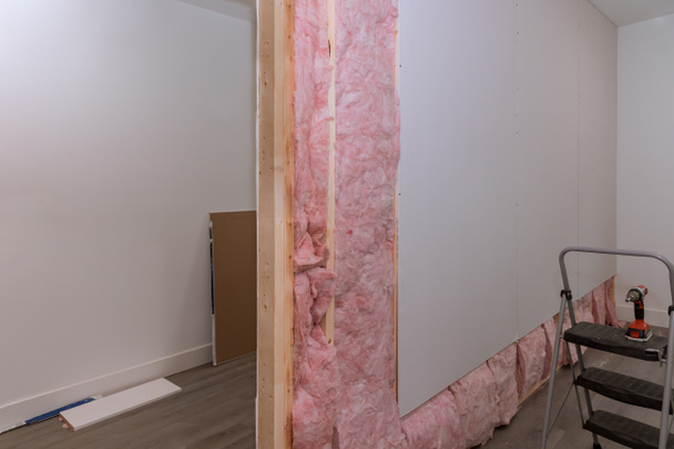Avvitamento muro a secco a parete su travi incorniciatura dopo l'installazione di isolamento acustico e termico per la nuova casa - Foto, immagini