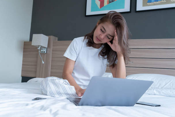 Beautiful Asian women on the bed with laptop. She was having a video conference meeting. WFH Working from home in quarantine lockdown. Social distancing Self Isolation - Photo, image