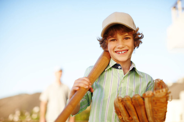 "Jsem všestranný. Oříznutý portrét mladého chlapce hrající baseball na dvoře se svým otcem v pozadí - Fotografie, Obrázek
