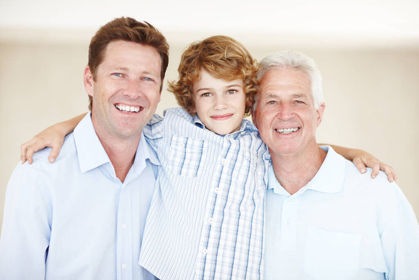 Trzyma rodzinę blisko siebie. Portret młodego chłopca stojącego z ojcem i dziadkiem - Zdjęcie, obraz