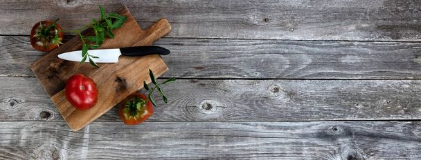 フラットレイアウト形式で素朴な木のテーブルの上にナイフとサーバーを切断と有機トマトを熟す  - 写真・画像