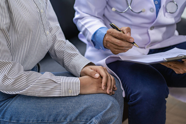 Doctor and patient consulting and diagnosis sitting at a table with advice of medicines to eat near window in hospital medical concept - Photo, Image