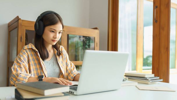 Eğitim ve okur yazarlık kavramı, kütüphanede dizüstü bilgisayarda ders dinleyen üniversiteli kız.. - Fotoğraf, Görsel