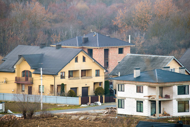 Casas residenciais com telhado coberto com telhas metálicas e cerâmicas na área suburbana rural. - Foto, Imagem