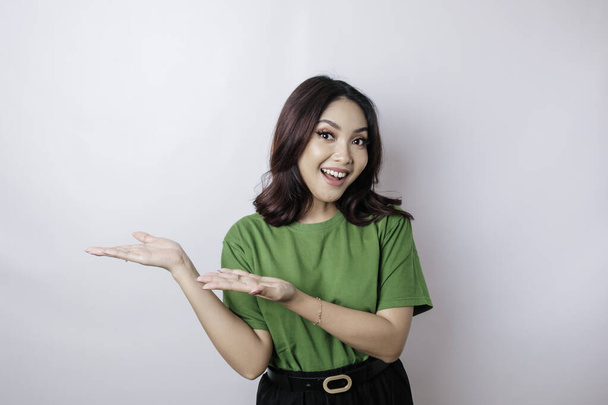 Smiling beautiful Asian woman pointing finger sideward to empty space isolated white background - Foto, Bild