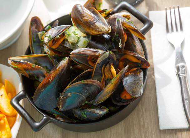Fresh bivalve mussels served with onion sauce in bowl - Foto, immagini