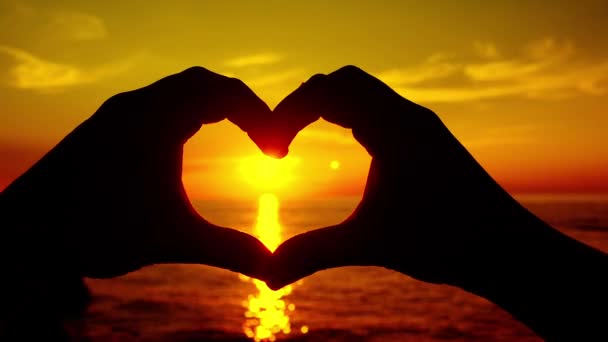 Sunset shining through heart shaped hands - Footage, Video