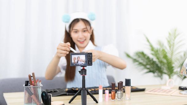 Красиві жінки з впливом соціальних медіа навчають макіяжу і використовують косметику, перед камерою для запису вхідного відео в прямому ефірі, інтернет-бізнес на концепцію блогерів краси
. - Фото, зображення
