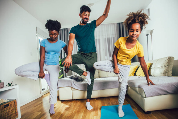 Gezonde ochtend stretching - familie doet gymnastische oefening thuis - Foto, afbeelding
