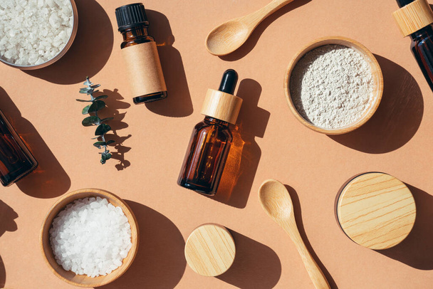Skincare natural cosmetic. Beauty concept for face and body care. Eco friendly packaging. Amber glass bottles different sizes with bamboo lid. Zero waste concept. Top view on beige background. - 写真・画像