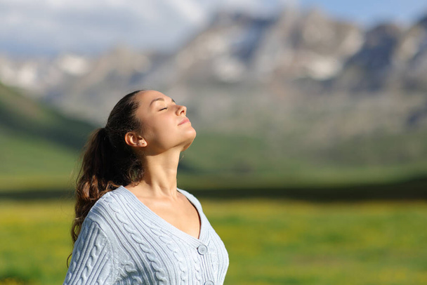 Relaxed casual woman breathing fresh air in the mountain a sunny day - Photo, image