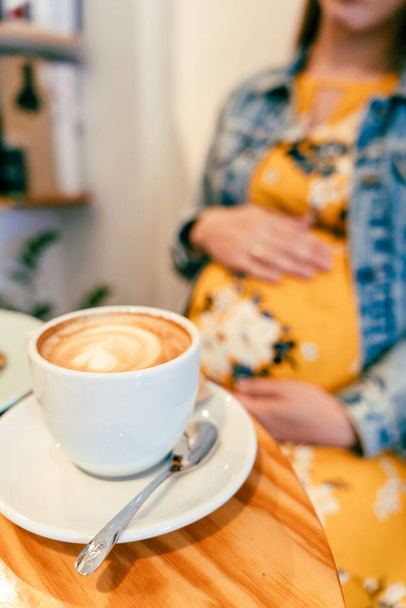 La mujer embarazada bebe café. Estilo de vida por la mañana con el embarazo feliz chica beber café expreso. Concepto para publicidad de productos de café - Foto, imagen