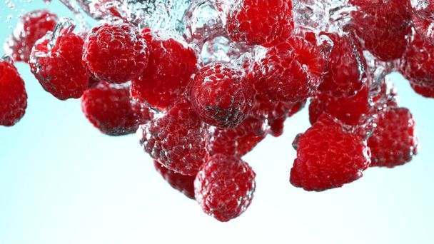 Raspberries pieces falling underwater on white background. Fresh juicy background. - Foto, afbeelding