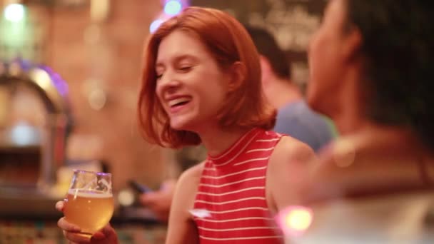 Szczęśliwa ruda młoda kobieta trzyma piwo śmiejąc się i uśmiechając. - Materiał filmowy, wideo