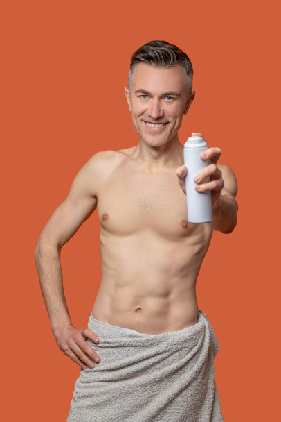 After shower. A mid aged man with a deo spray looking cheerful after shower - Foto, Bild