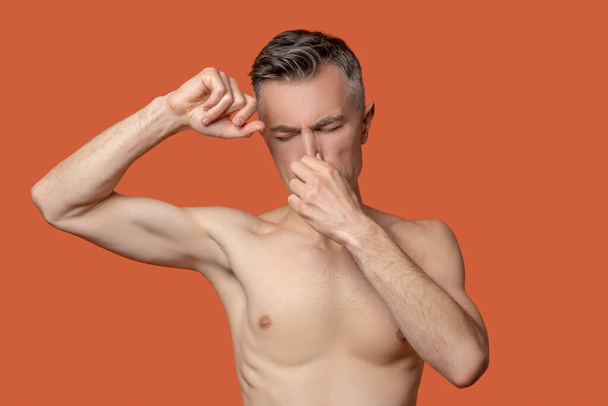 Stinky smell. A man closing his nose from a disgusting smell - Фото, изображение