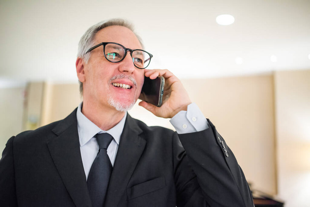 Portrait of a senior businessman using a cell phone - Foto, Bild