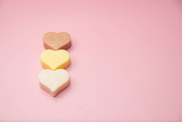 Heart shaped pink bar of soap on a light pink background. Top view, copy space. Heart shaped soaps. Importance of personal hygiene care. Copy space - Foto, Imagen