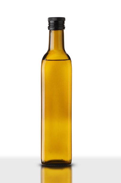 bouteille en verre plein d'huile sur fond blanc - Photo, image