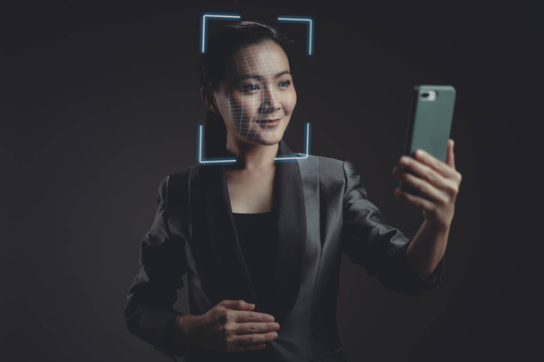 Asiatin scannt Gesicht per Smartphone mit Gesichtserkennungssystem Isoliert im Hintergrund. - Foto, Bild