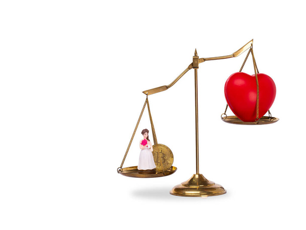 Love Money Symbol Concept (em inglês). Forma coração vermelho no comércio de câmbio balança para Materialismo, noiva, bitcoin e comprar amante da venda. Amor por dinheiro em balança isolada em fundo branco - Foto, Imagem