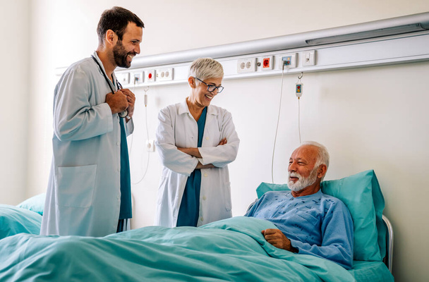 Doctors consulting a mature man patient in hospital. Healthcare people insurance concept - Foto, Imagen